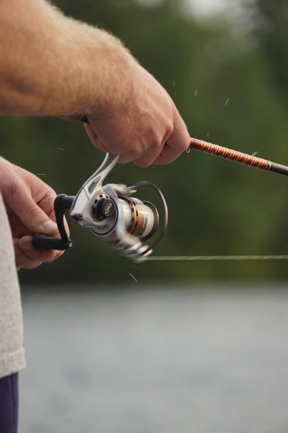Close-up of a rod and spinning reel in an angler’s hands